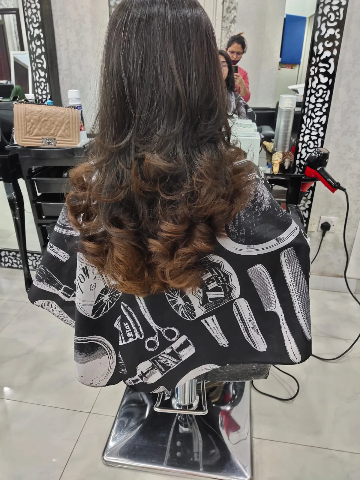 Long brunette hair styled into soft curls after a blow-dry