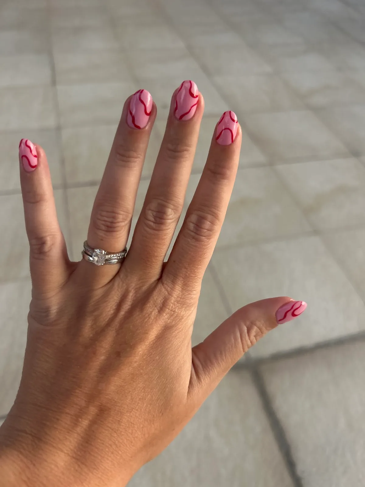 Pink nails with red swirl line art