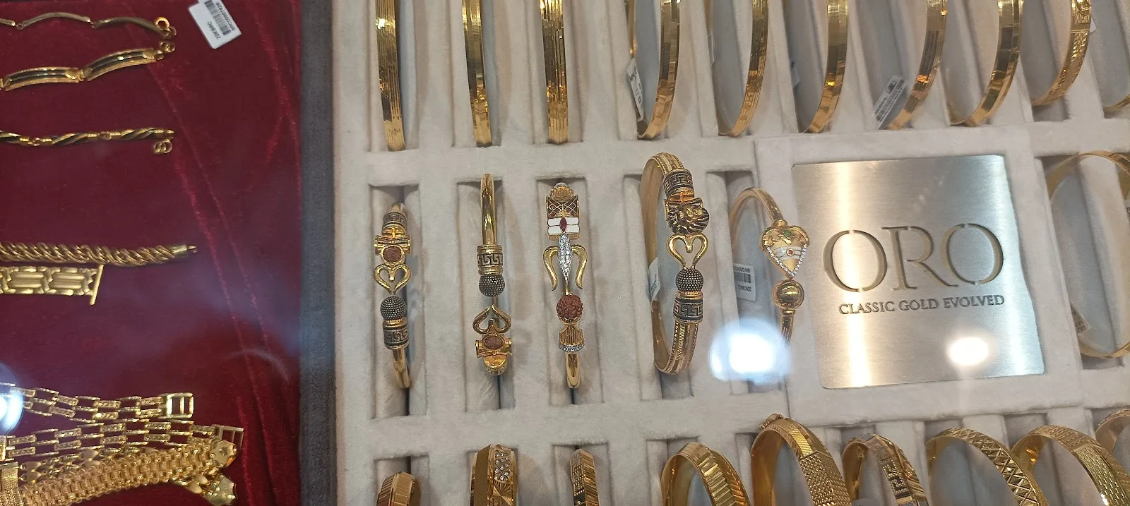 Gold bracelets arranged in a velvet display tray