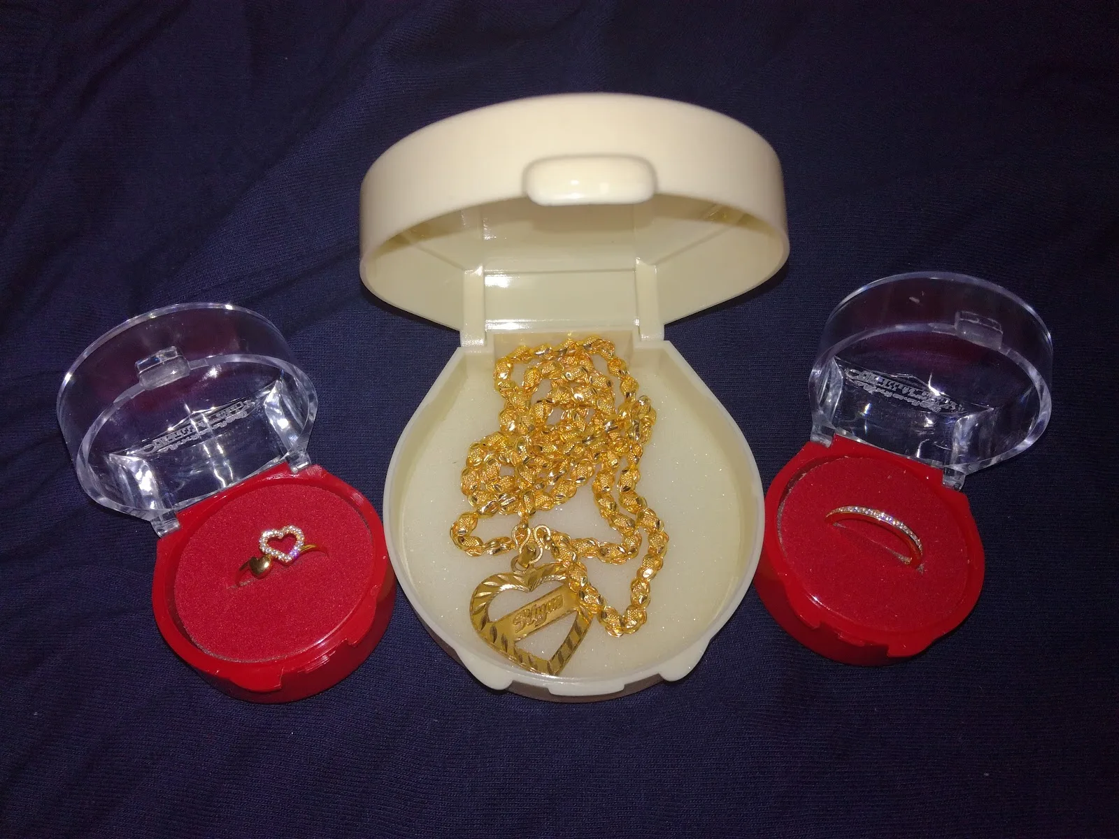 Gold chain with heart pendant and two rings in gift boxes