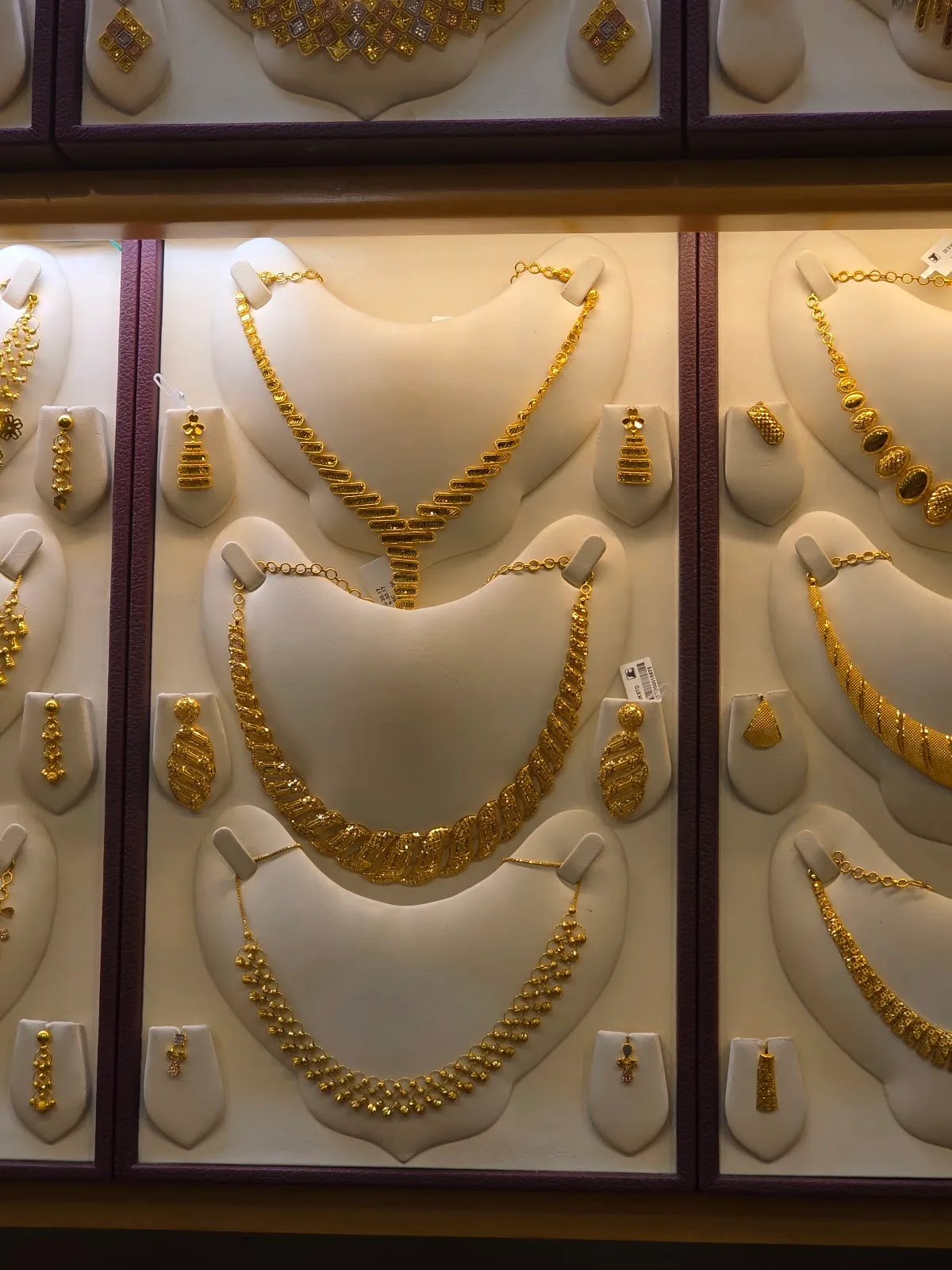 22K gold necklaces and bridal sets on display busts at Chittilappilly Jewellers