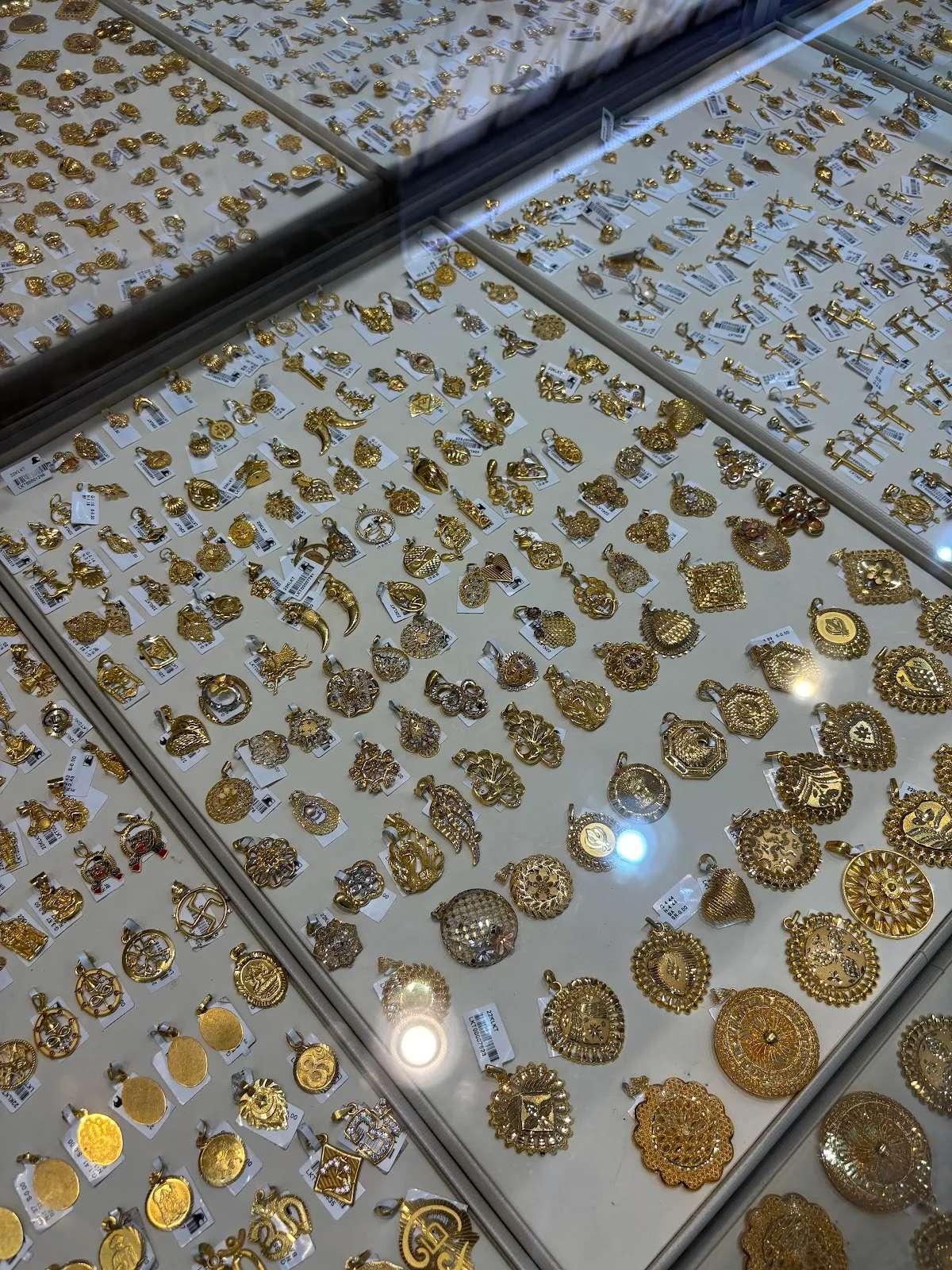 Tray of assorted gold pendants and charms
