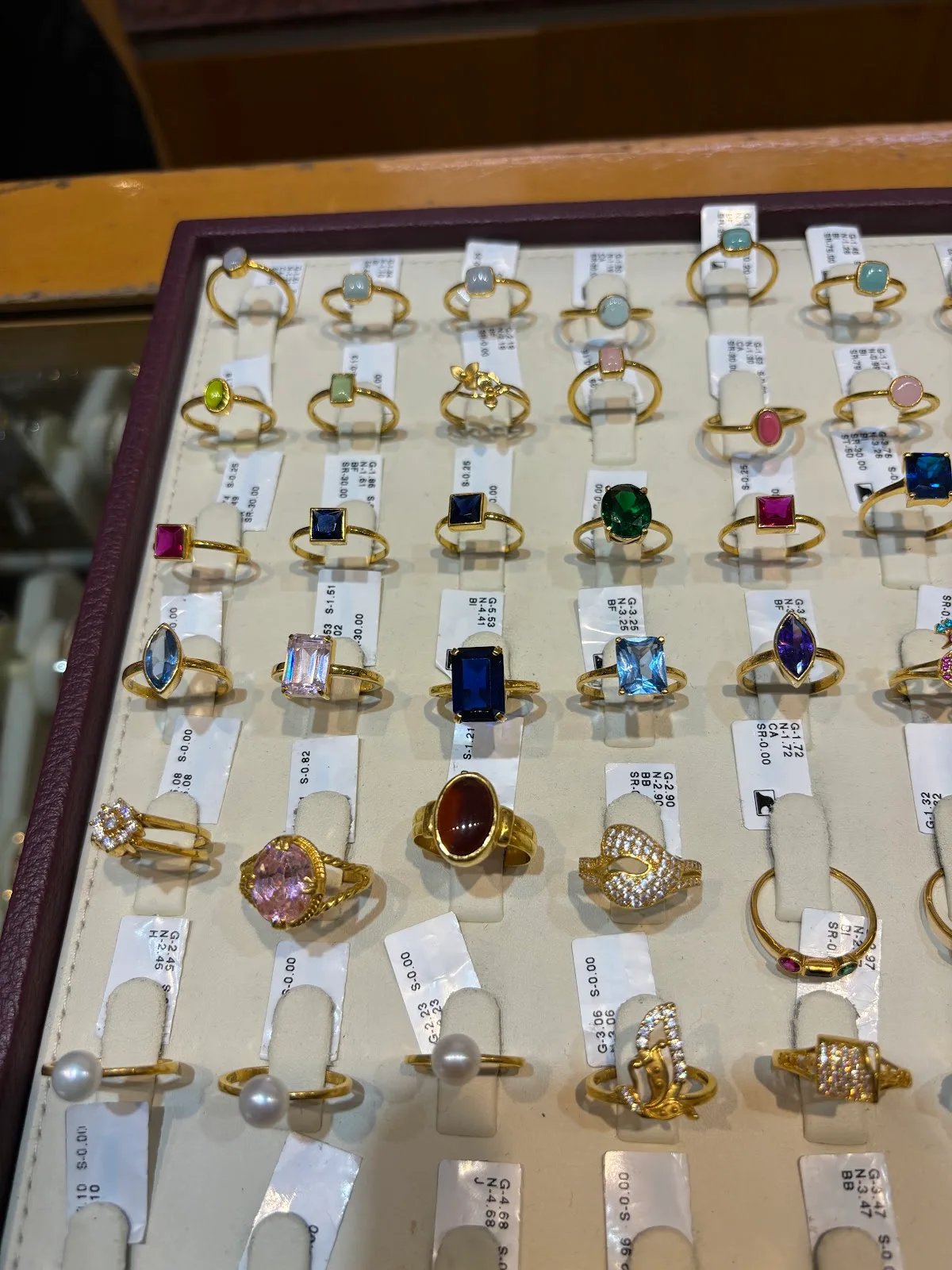 Display tray of gold rings set with coloured gemstones
