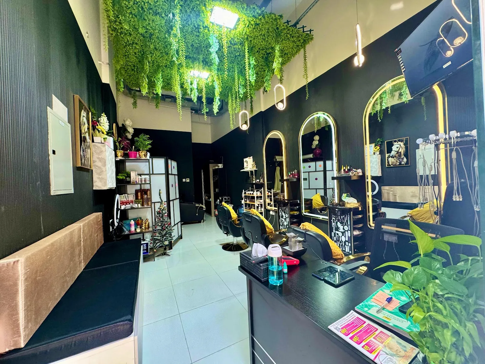 Inside The Royalty Beauty Salon — black walls, gold mirrors and hanging greenery