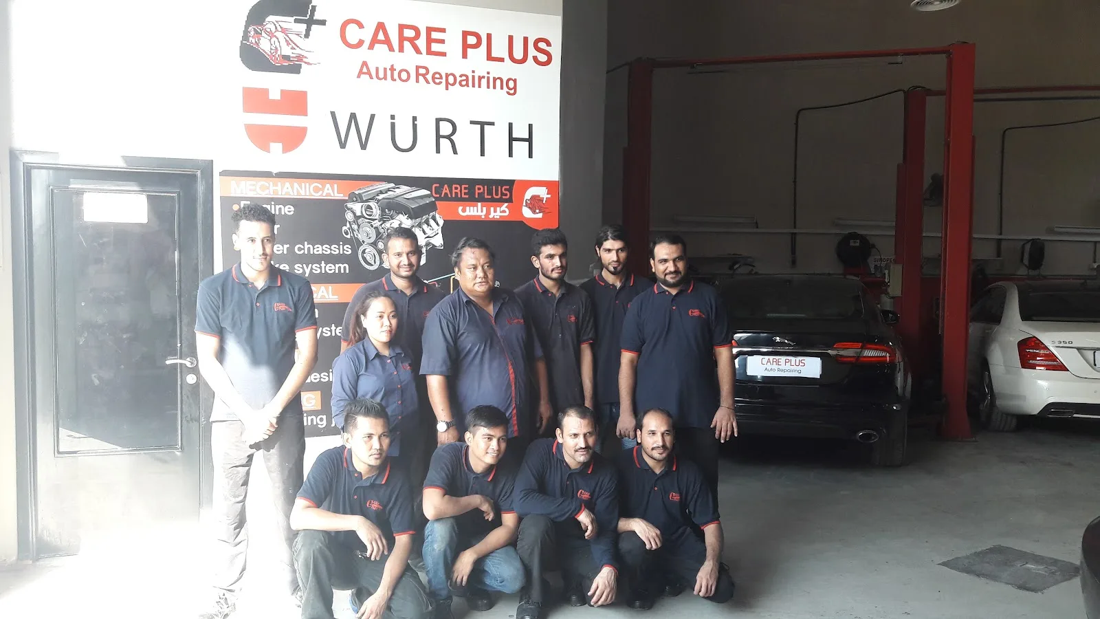 The Care Plus Auto Repairing team in matching uniforms inside their Al Quoz workshop