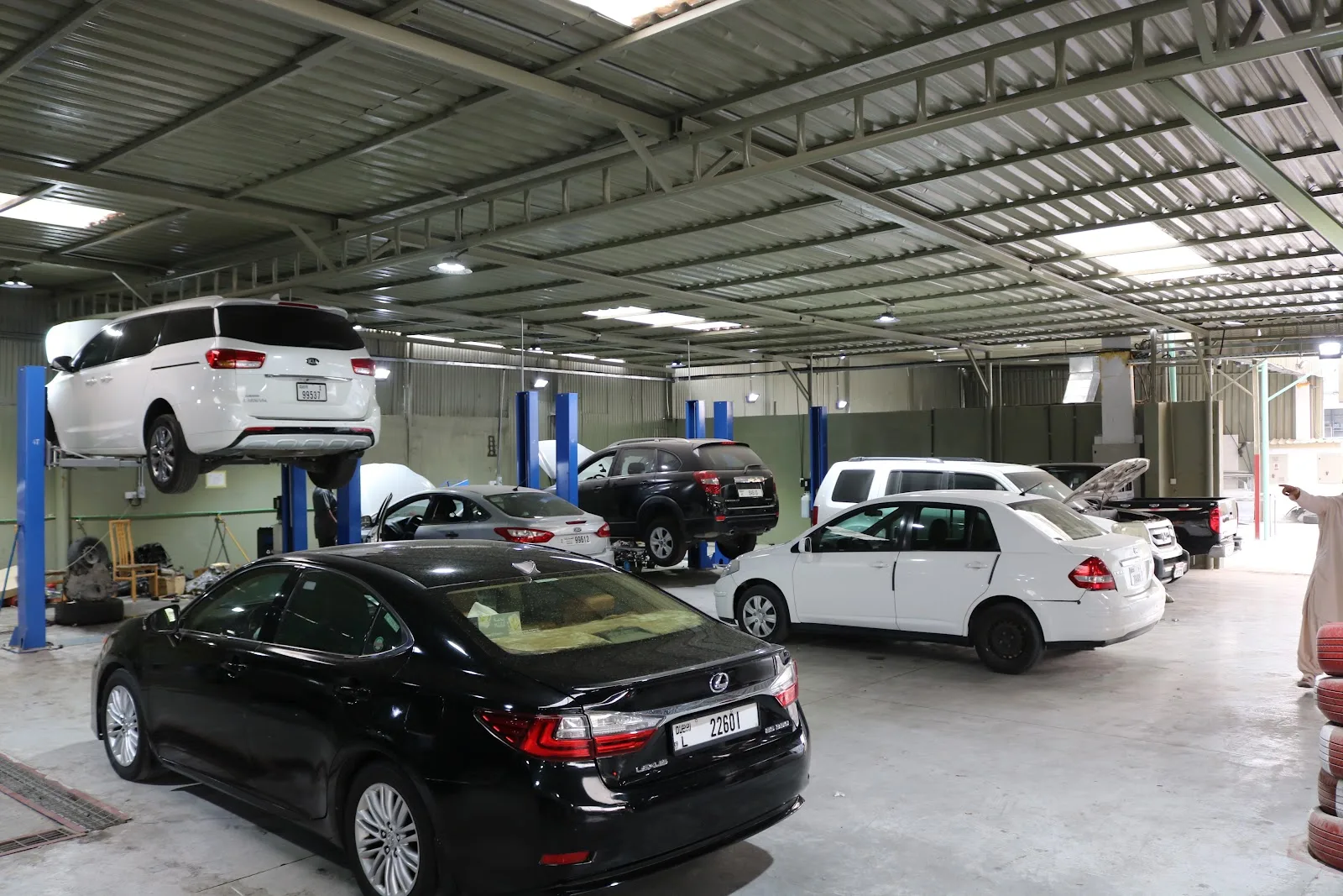 Jahan Auto Repair main service hall with multiple cars on two-post lifts in Umm Ramool