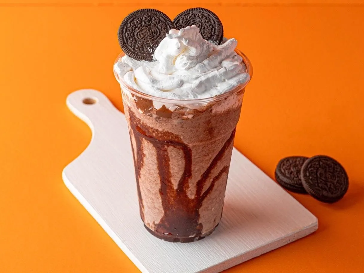 Tall dessert shake topped with whipped cream and cookies