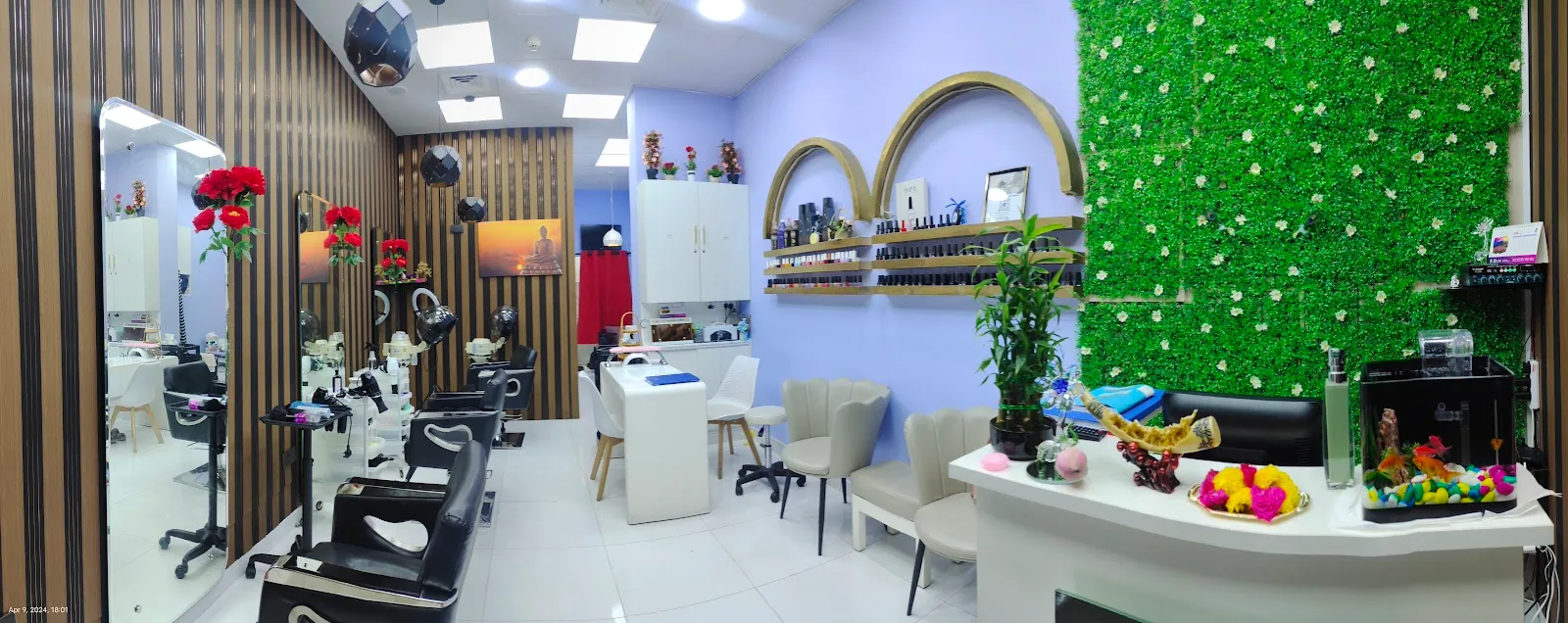 Inside Tint Saloon — styling chairs, nail station and a flower wall