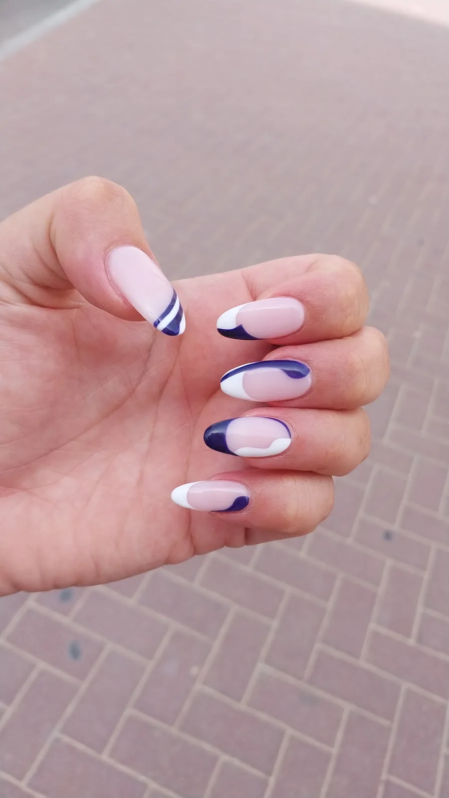 Navy and white swirl design on almond gel nails