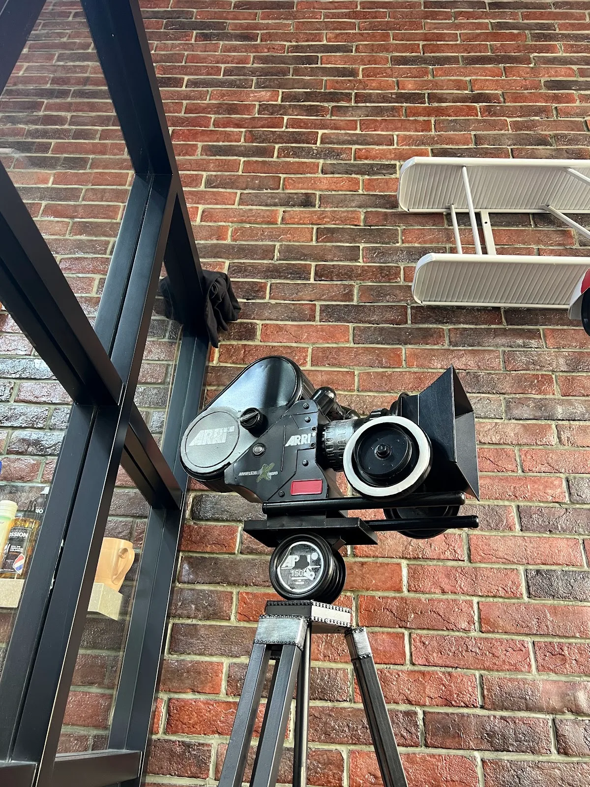 Vintage ARRI film camera mounted on the shop's brick wall