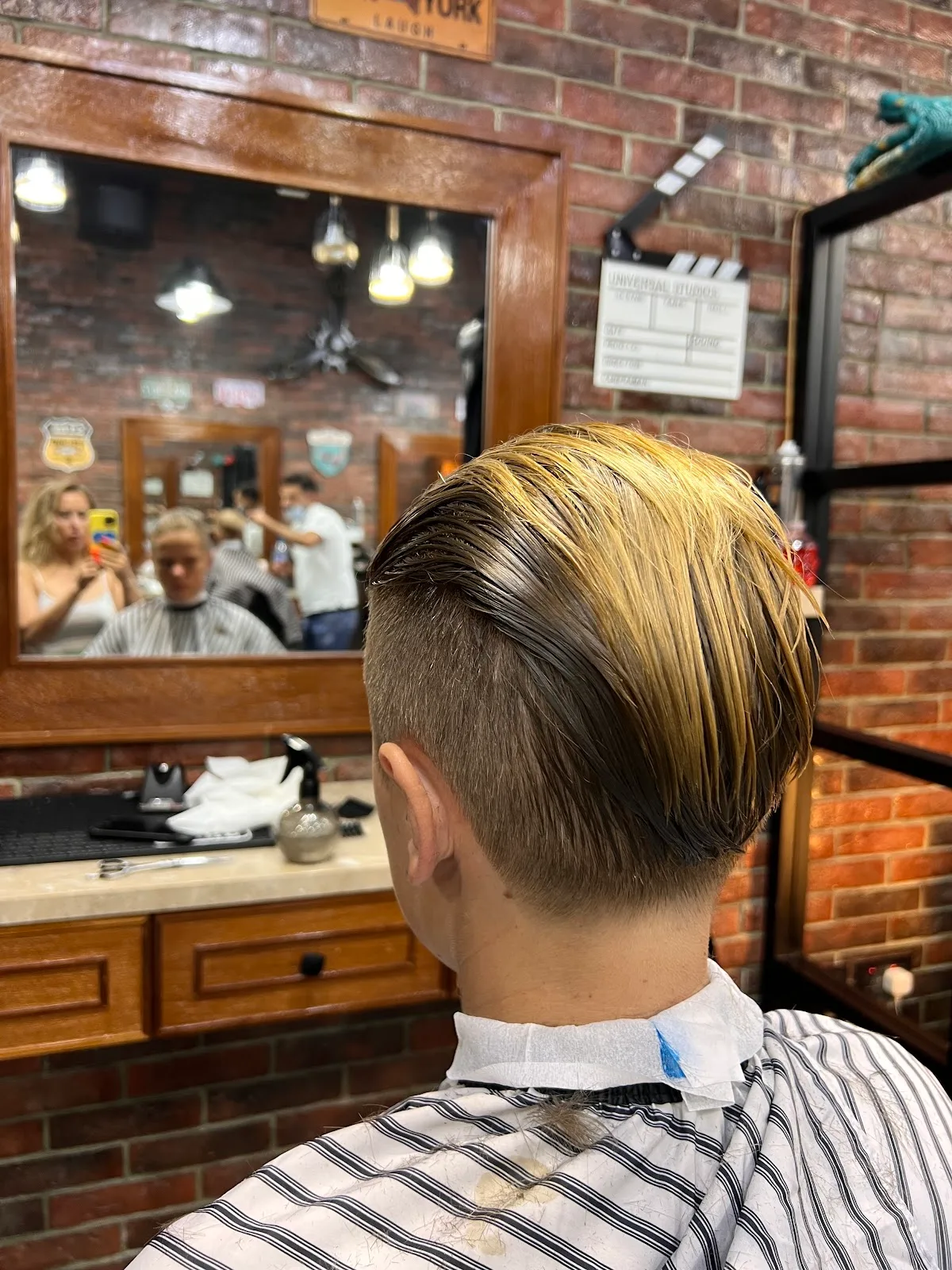 A finished slick-back cut at the back-bar mirror