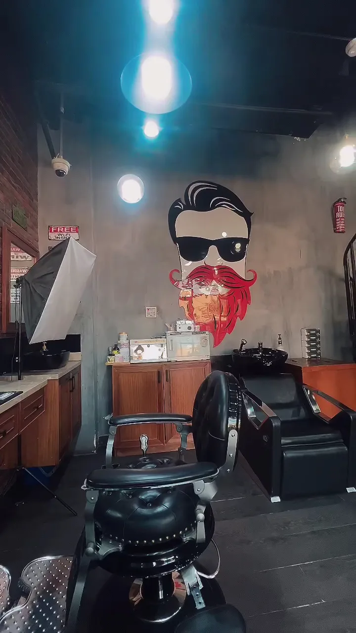 The Stars Barber interior with the signature bearded mascot mural and black leather barber chairs