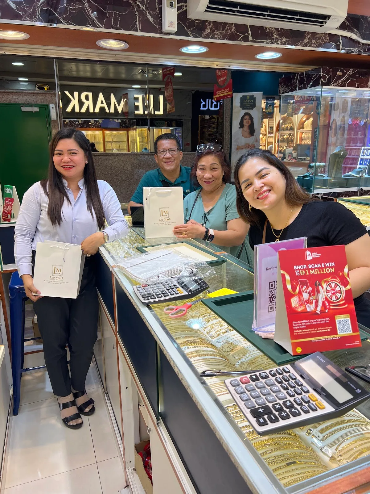 Happy customers holding Lee Mark shopping bags