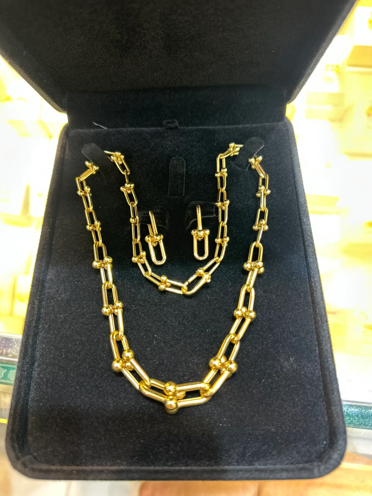 22K gold U-link necklace and earring set displayed on black velvet at Lee Mark Jewellery