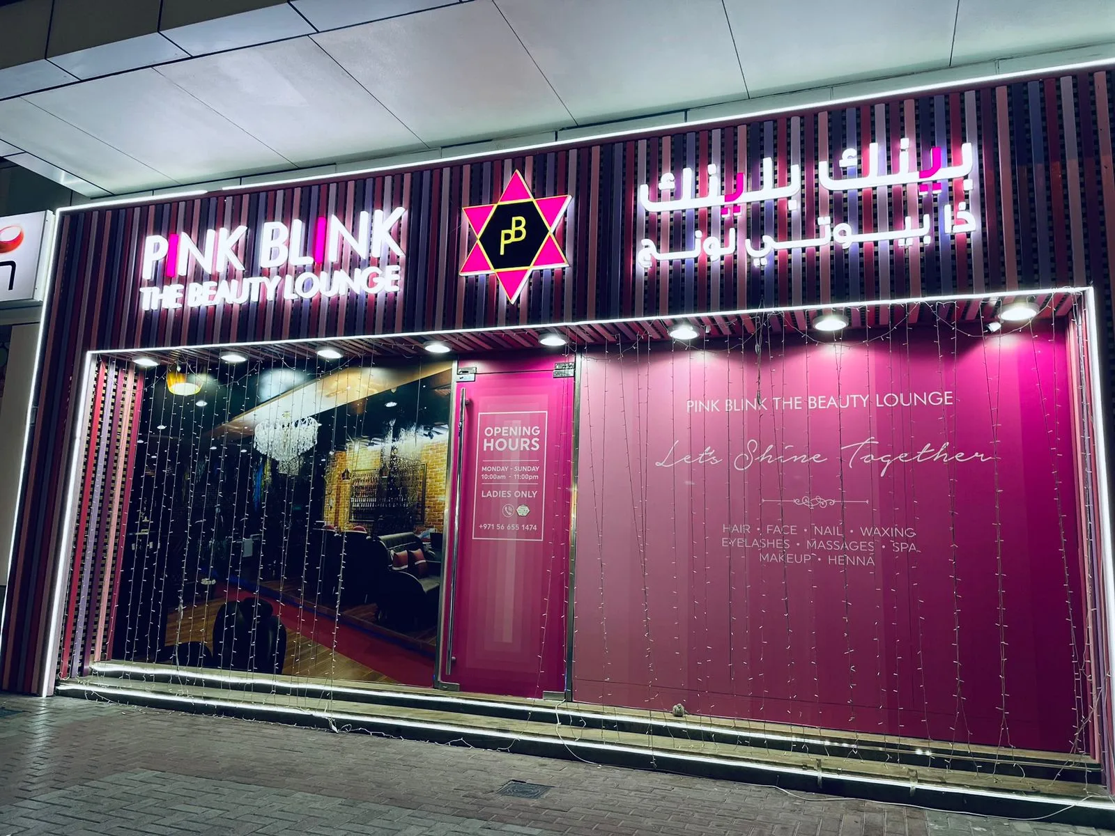 Pink Blink The Beauty Lounge storefront in Al Karama at night, lit in pink