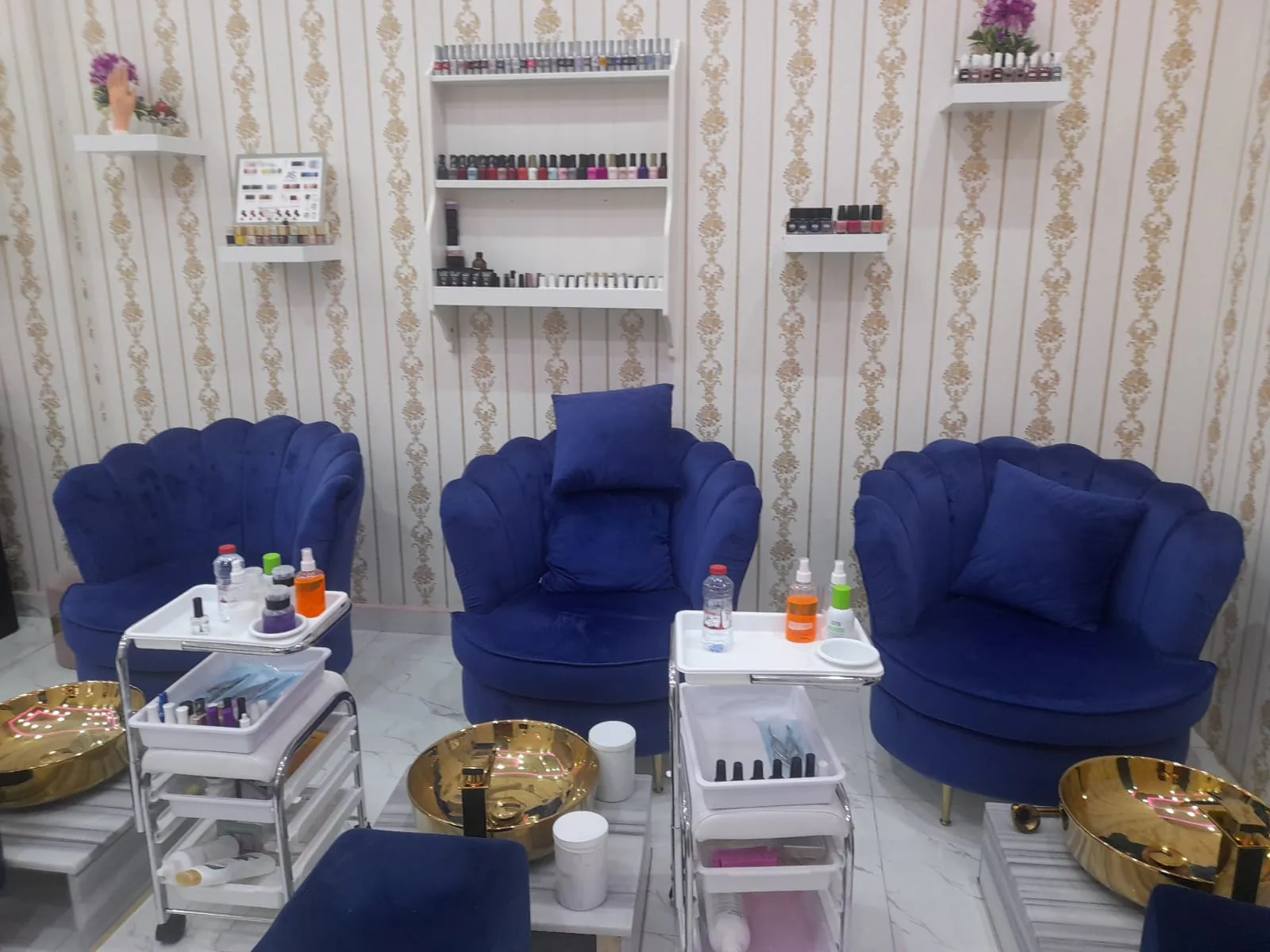 Inside Al Anaqa Al Thahabia — royal blue velvet salon chairs and gold pedicure bowls