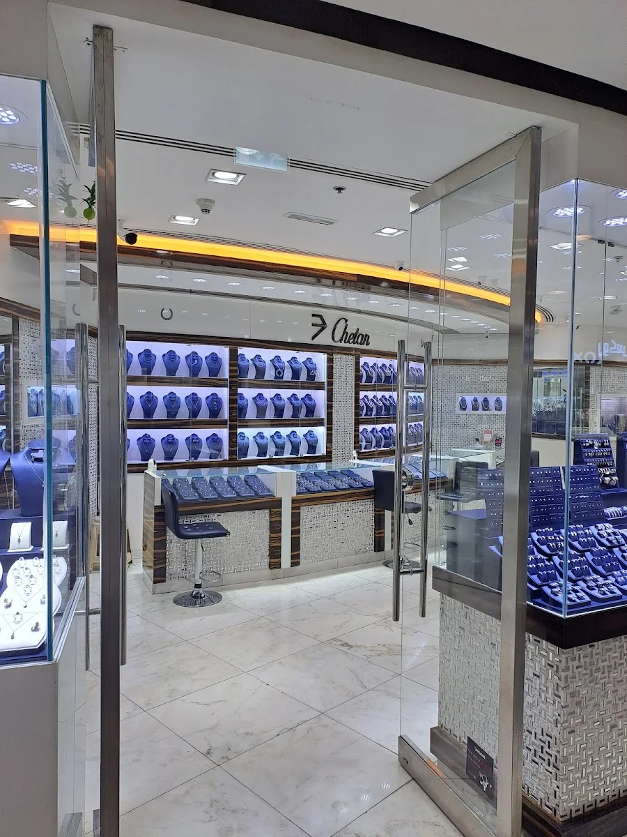 Inside the Chetan Jewellers boutique — navy velvet display cases of gold and diamond jewellery under warm lighting