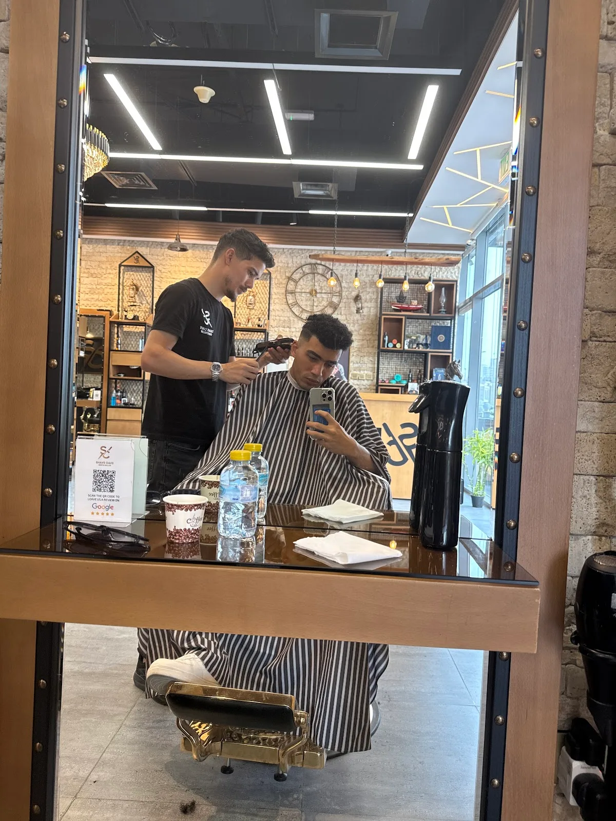 Barber cleaning up a client's neckline with clippers at Shave Cave