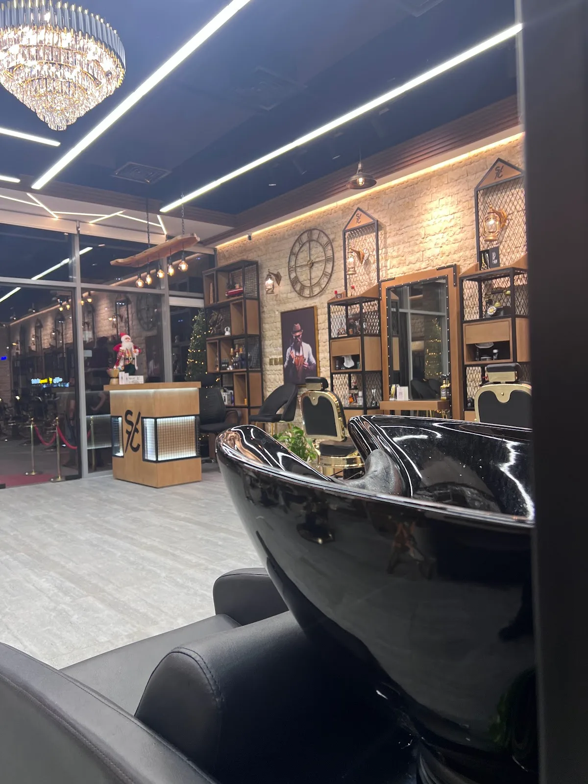 Black wash basins and lounge chairs under a chandelier at Shave Cave