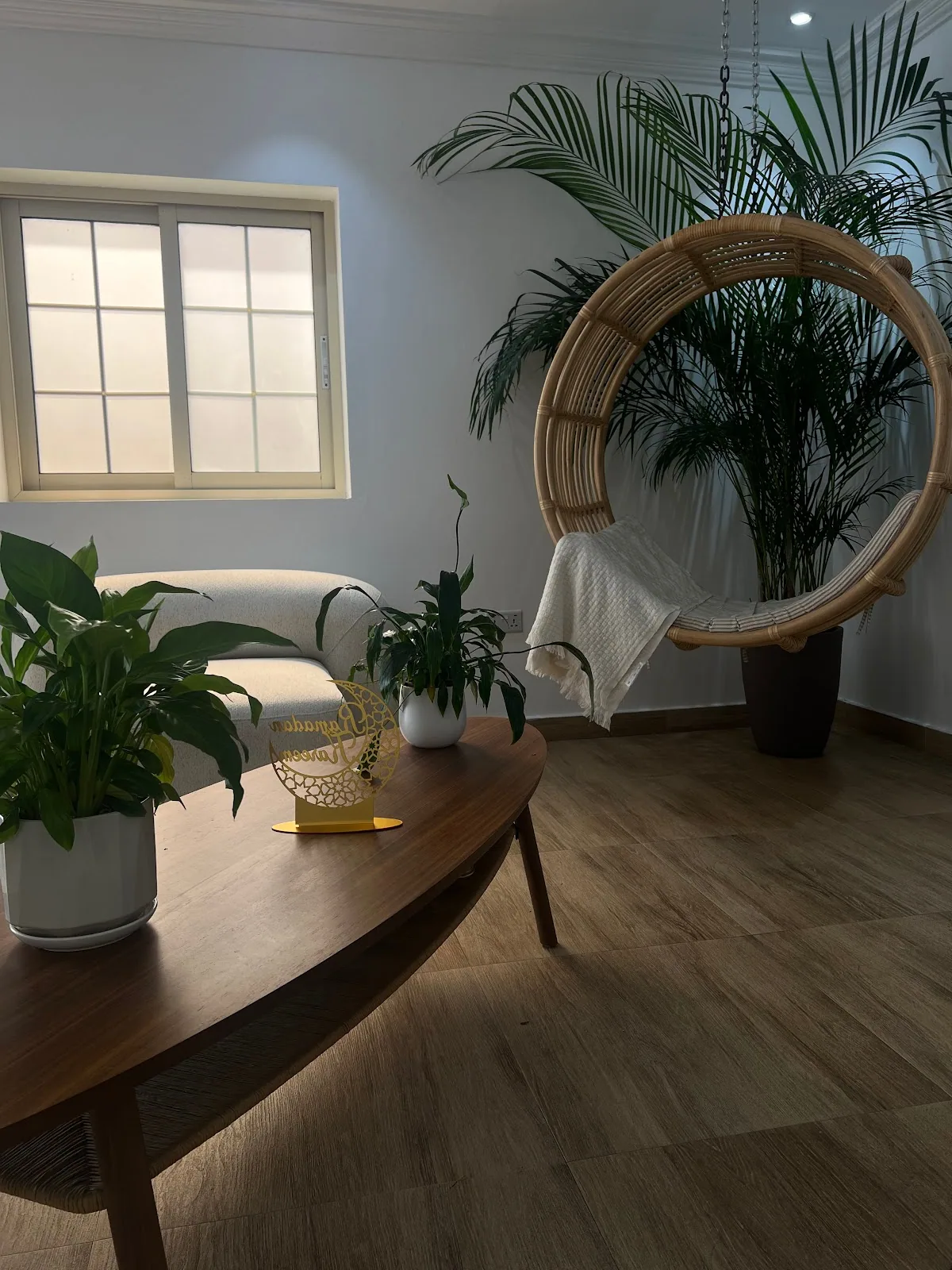 Karmela lounge interior with rattan swing chair and palms