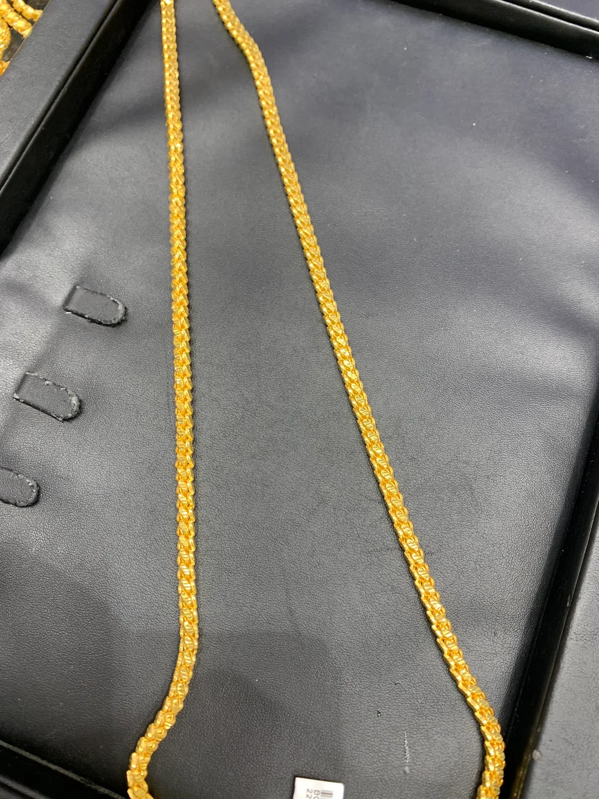 22K gold chain on a display tray