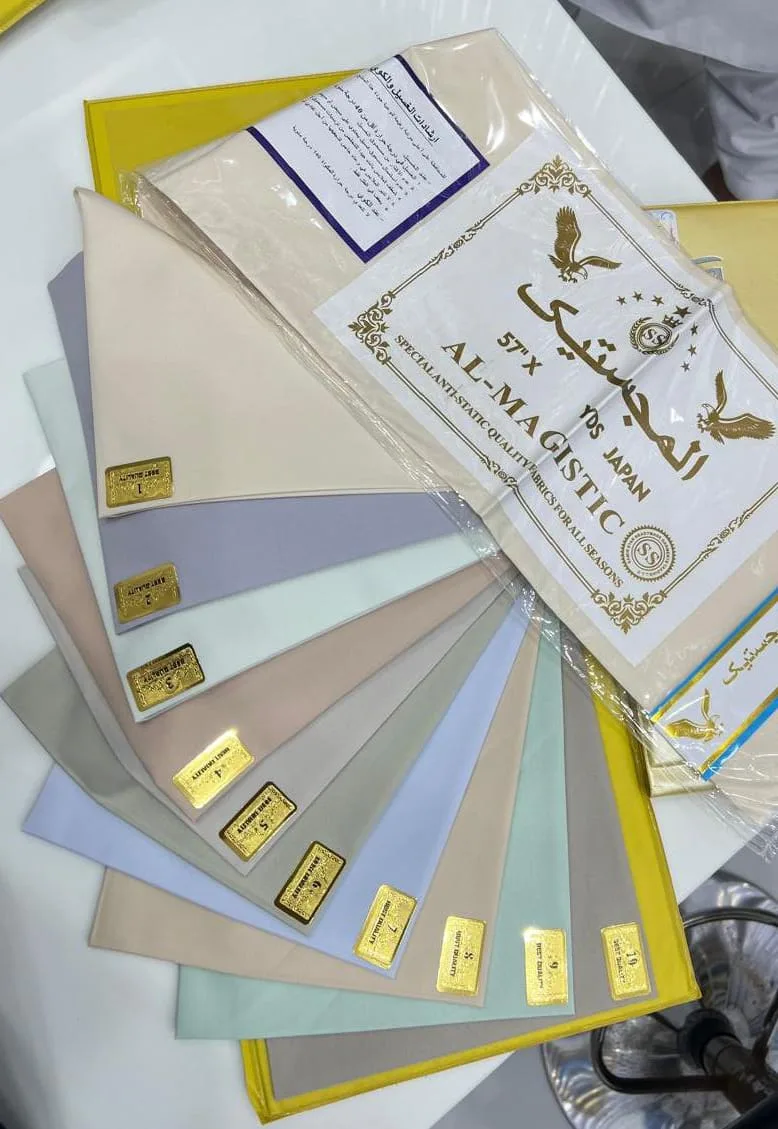 Fan of suiting and shirting fabric swatches in pastel and neutral tones at Rizwan Raza Gents Tailoring