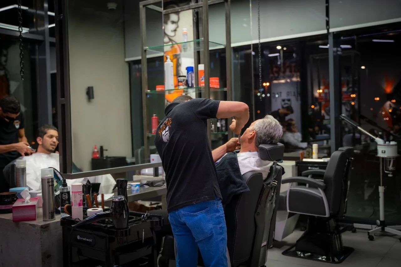 Barber trimming a client's beard with detail work