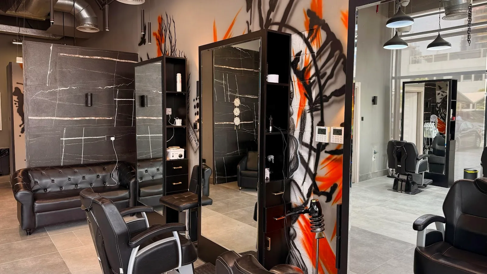 Leather lounge seating beside marble panels and graffiti walls