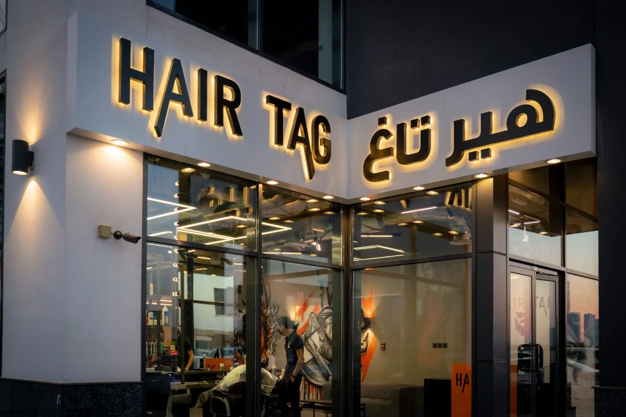 Hair Tag storefront and lit bilingual HAIR TAG sign at dusk