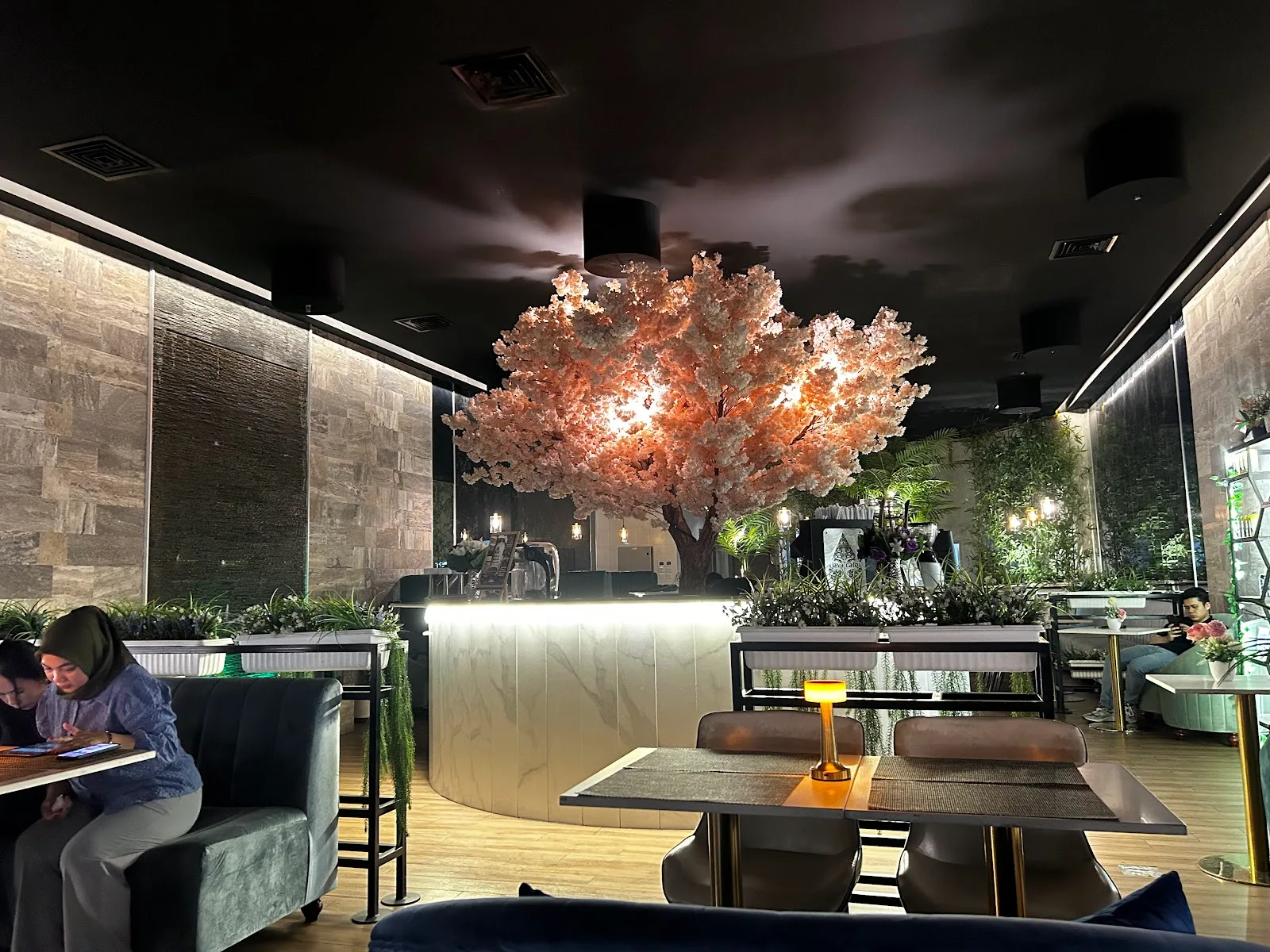 The dining room at Bandung Restaurant & Cafe, lit by a large blossom tree above the marble bar