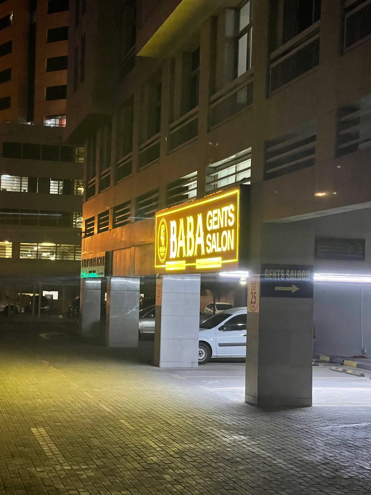 BABA Gents Salon lit sign at night with haircut and beard pricing
