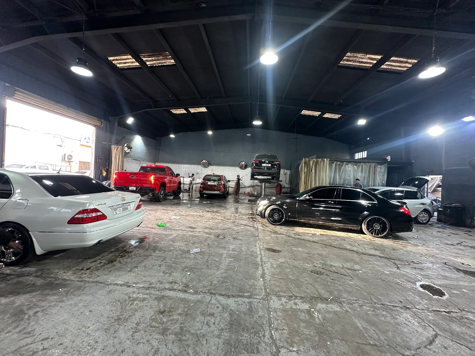 Inside the Ras Al Khor workshop with several cars in the wash bays
