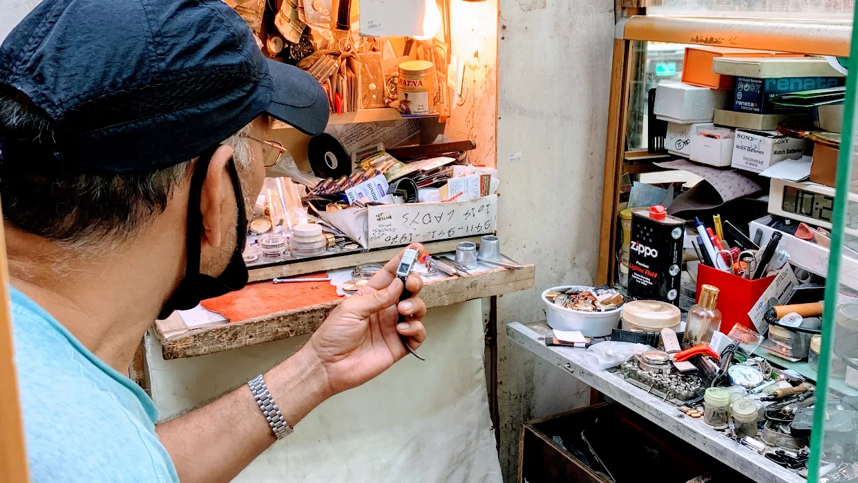 The watchmaker's bench packed with parts, batteries and tools