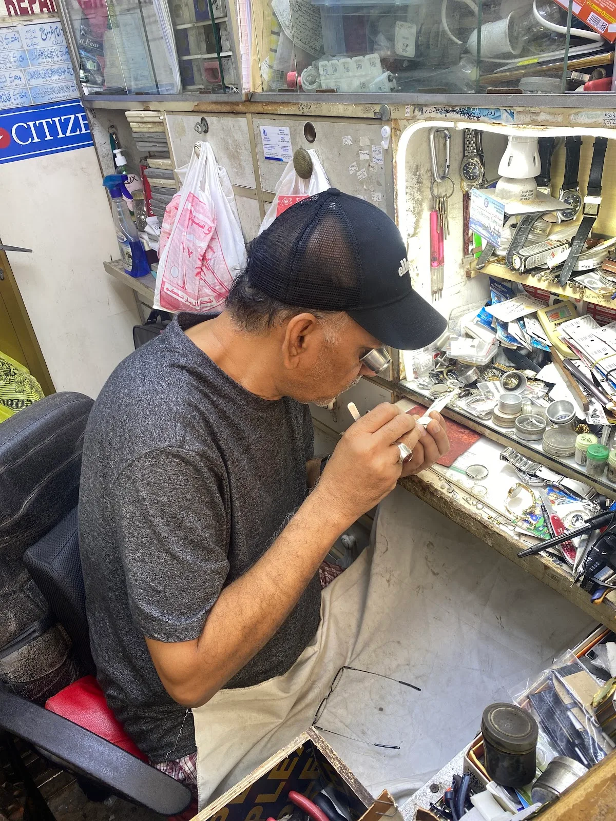 A watch specialist using a loupe at the cluttered repair bench
