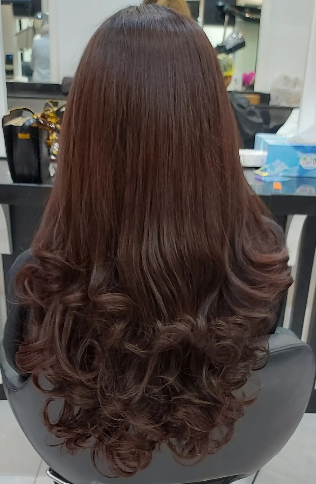 Glossy brown blow-dry with bouncy curled ends, styled at the salon