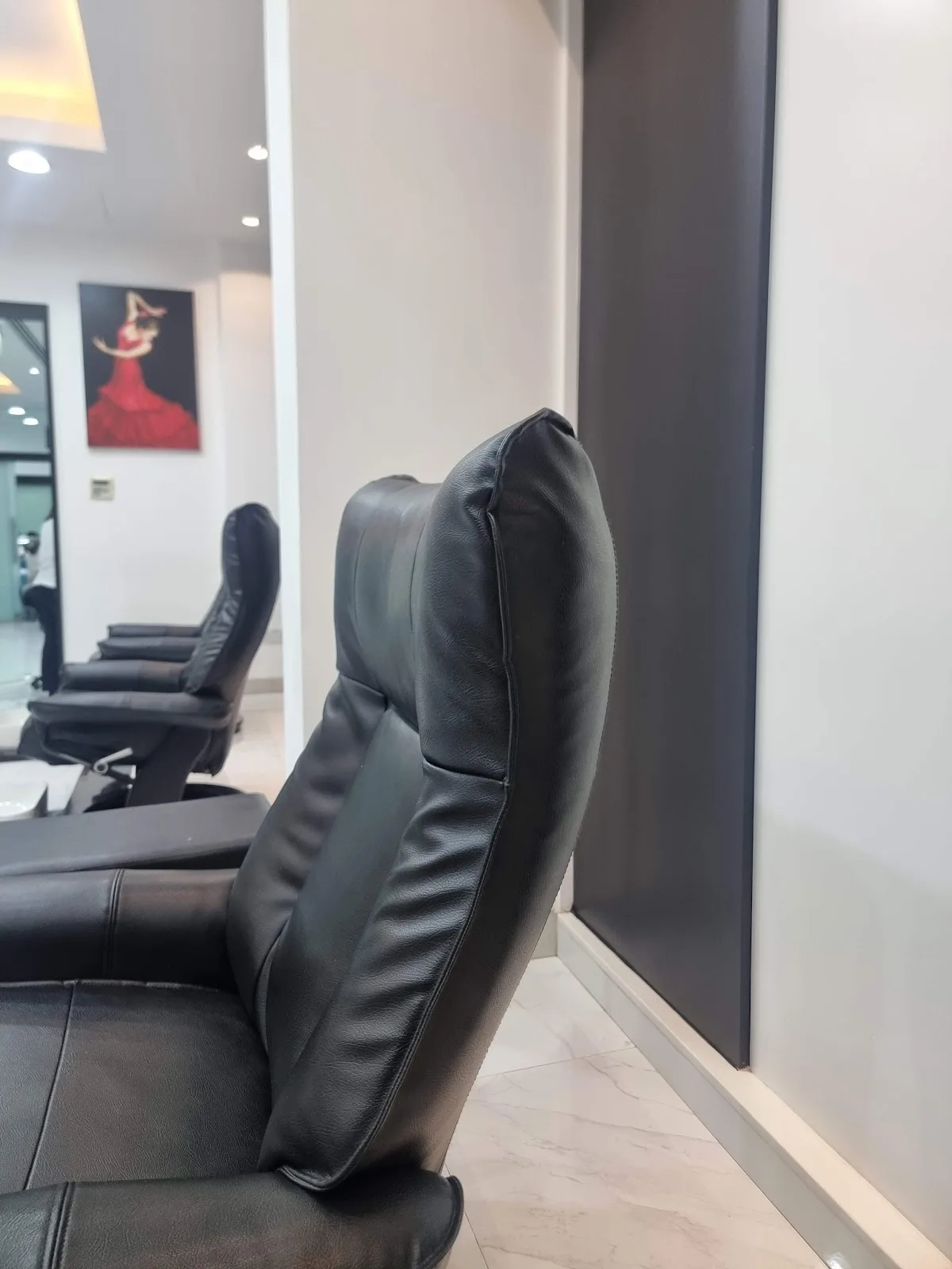 Styling chair beside framed flamenco artwork inside the salon