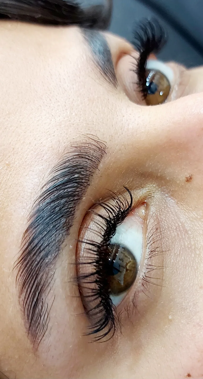 Close-up of full lash extensions and a groomed brow