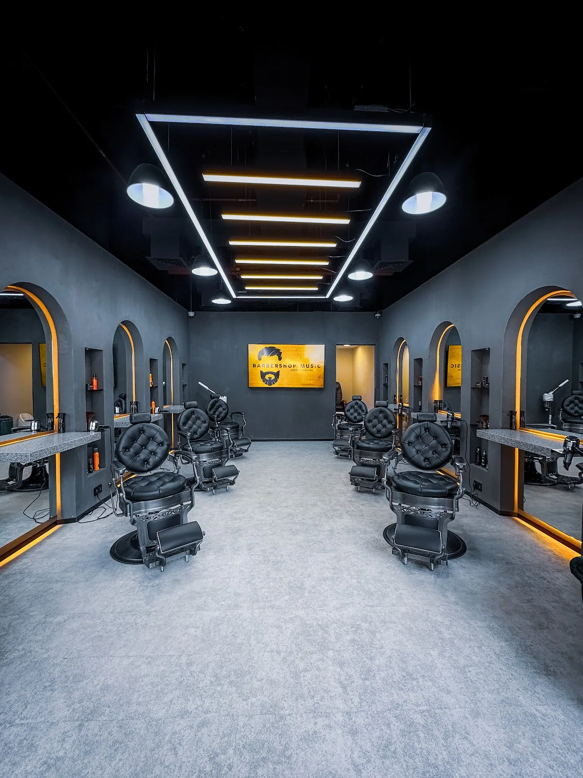 Diveno main grooming floor with rows of barber chairs under gold-lit arches