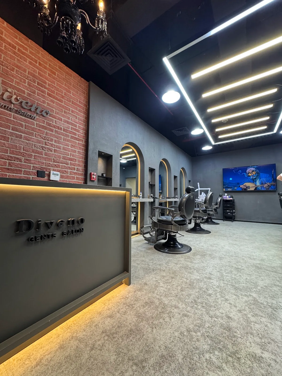 Diveno Gents Salon interior â€” reception desk, gold-lit arched stations and barber chairs