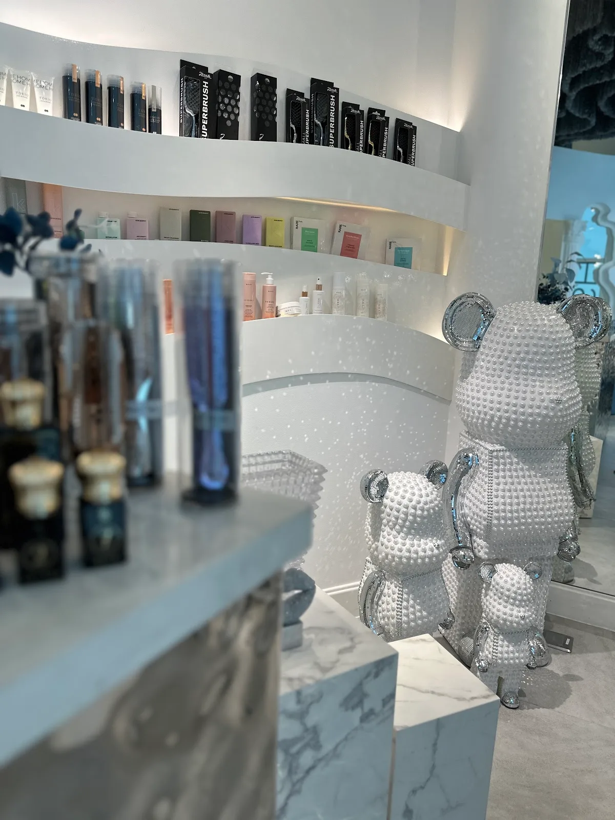 Crystal-pearl bear sculptures beside the product shelves at CRUSH