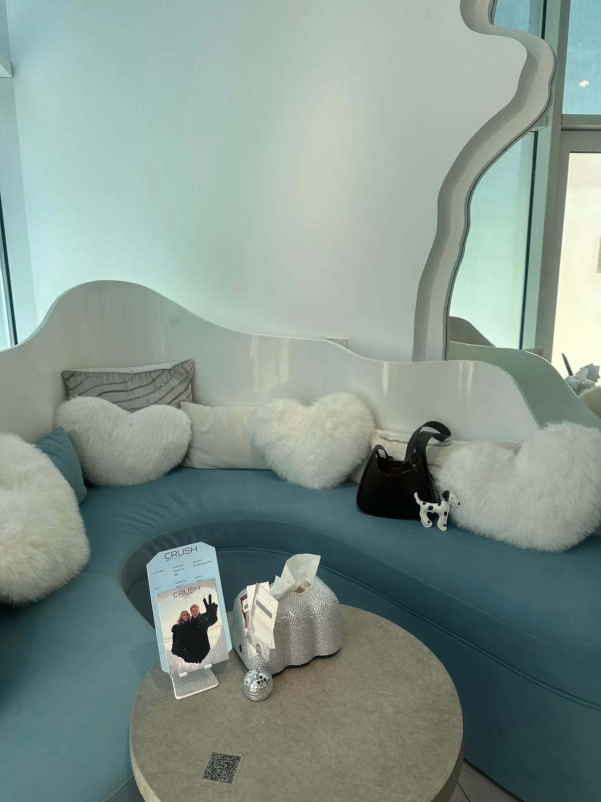 The blue velvet waiting lounge at CRUSH with heart cushions and a wavy mirror
