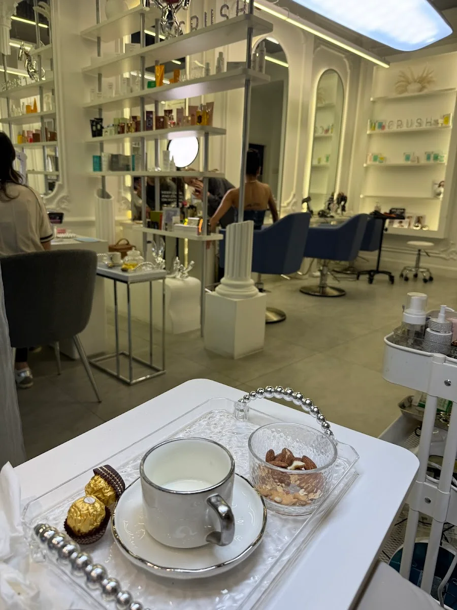 Inside CRUSH beauty salon: white styling chairs, classical columns and product shelves in Business Bay, Dubai