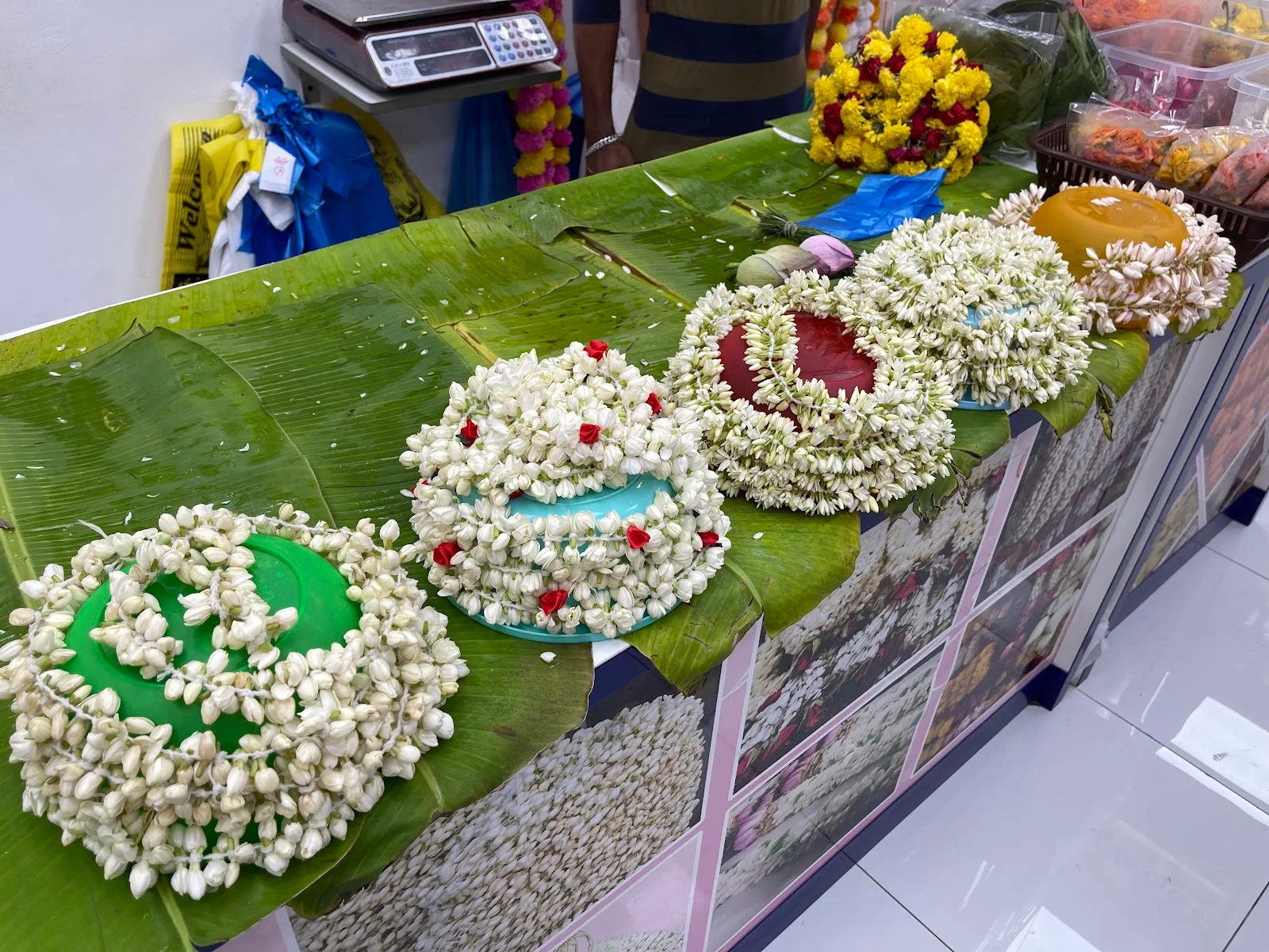 Fresh jasmine garlands arranged on banana leaves at Perumal Flowers