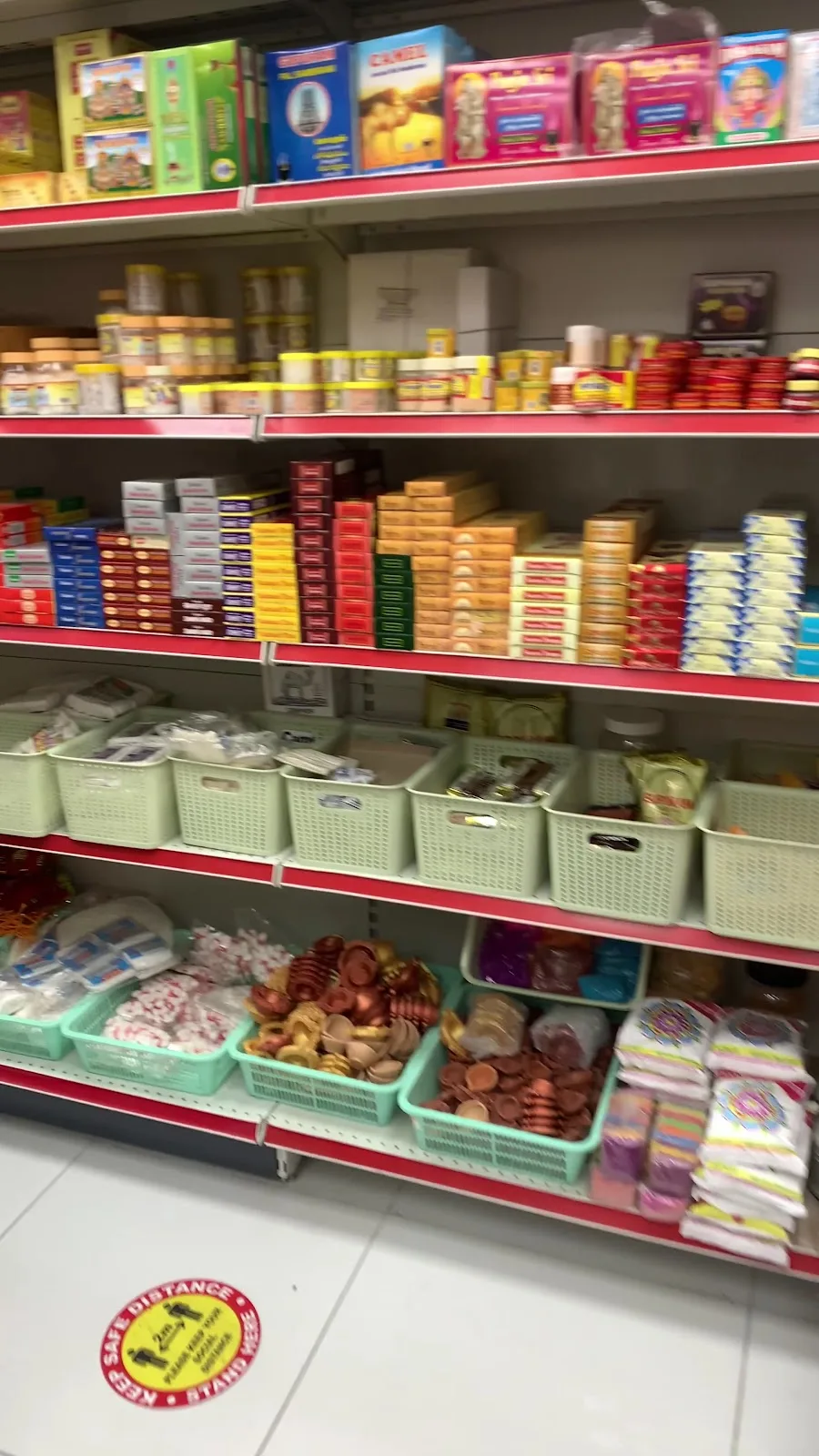 Shelves stocked with pooja items and Indian provisions