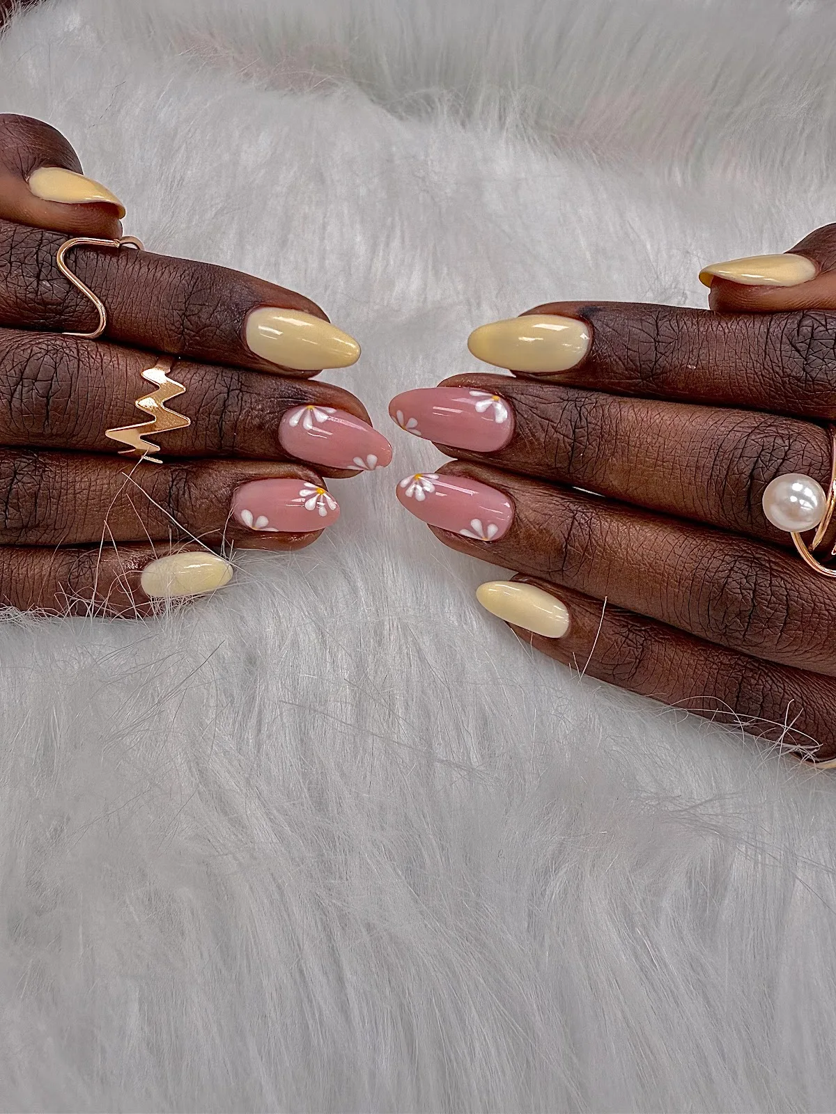 Pastel yellow and pink nails with hand-painted daisies
