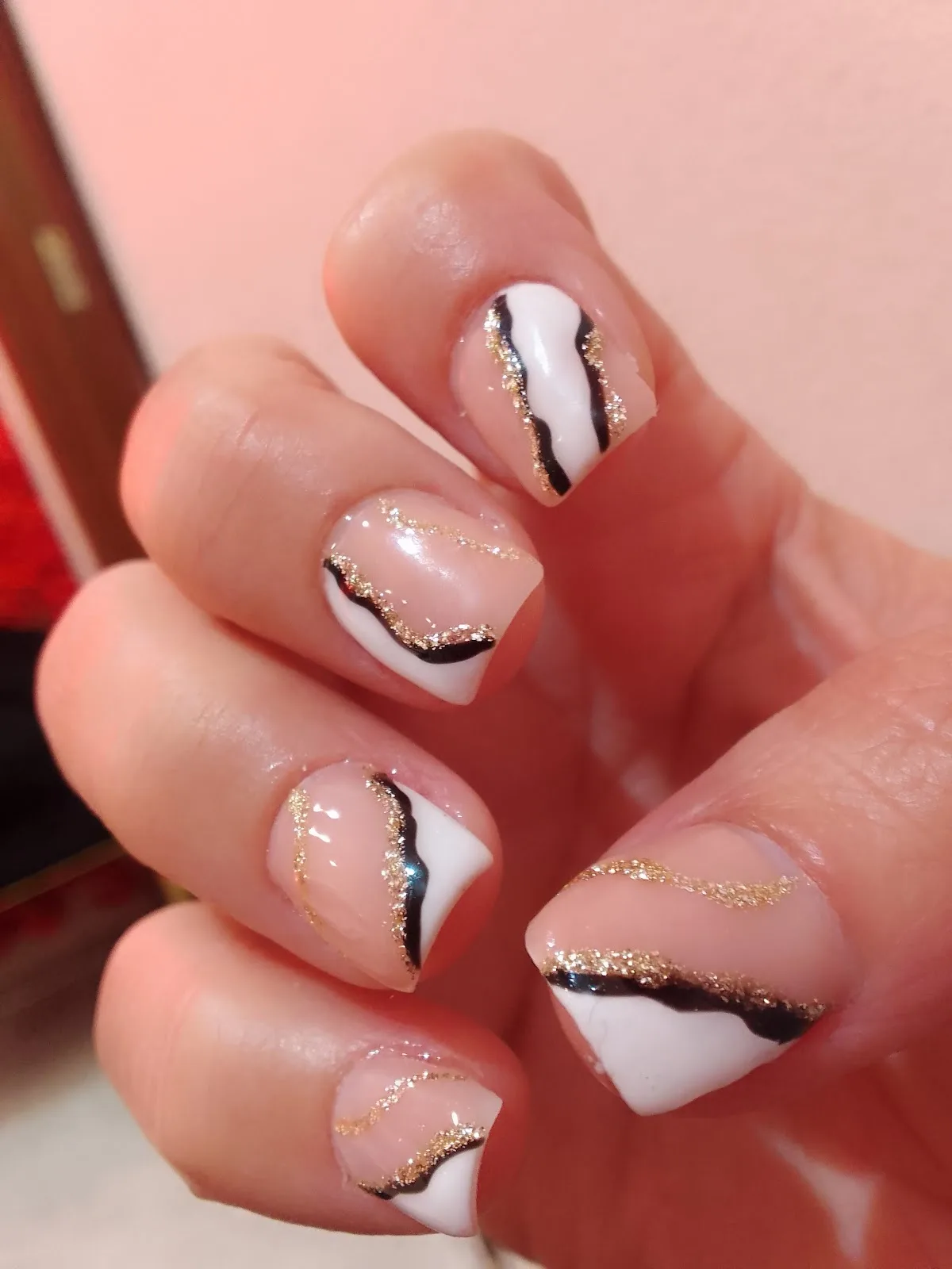 White nails with black and gold swirl detail