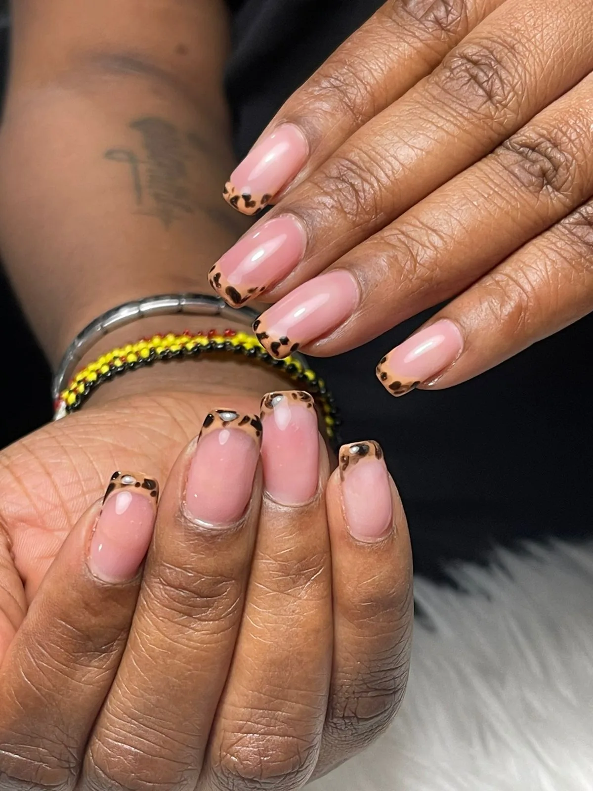 Nude nails with leopard-print French tips