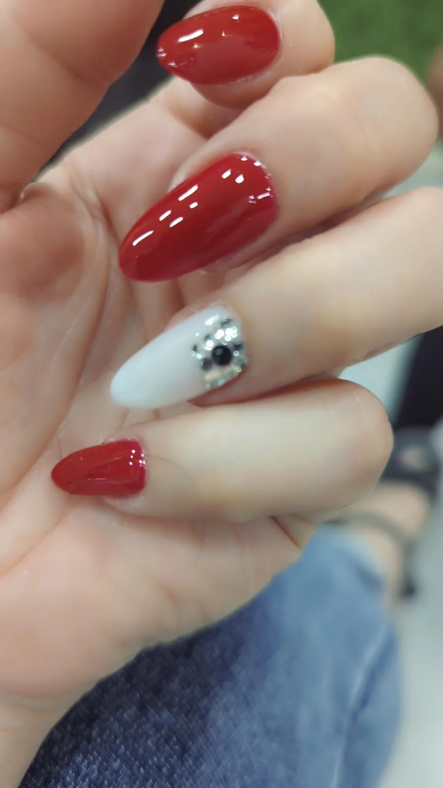 Red almond nails with a rhinestone accent nail