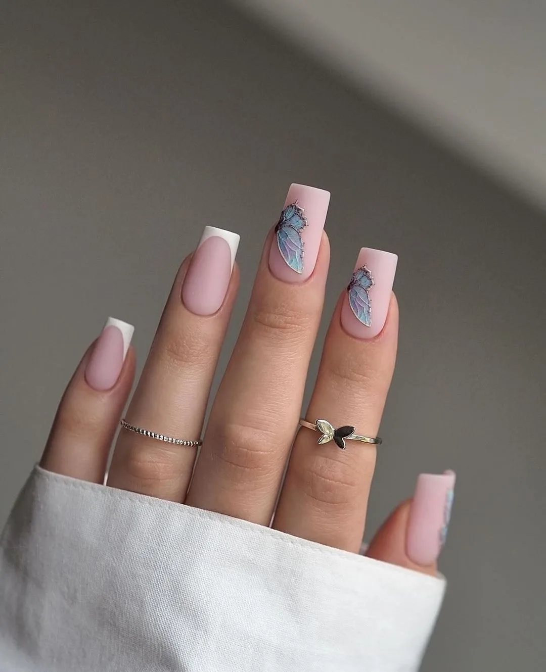 Matte pink French nails with butterfly art
