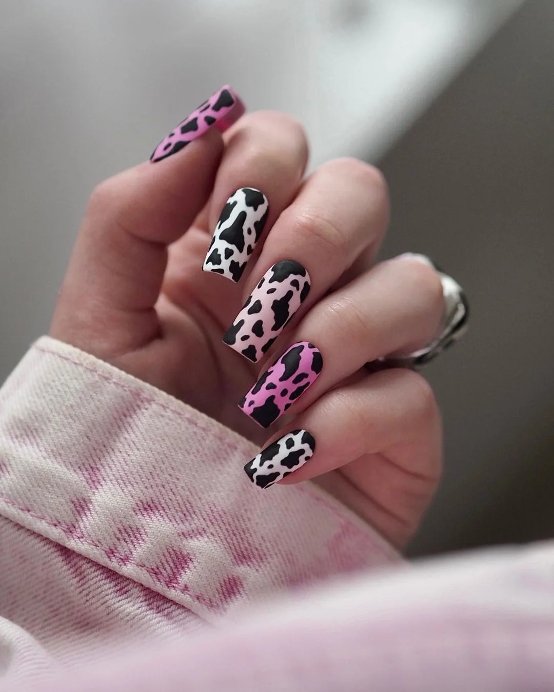Pink and black cow-print nail art